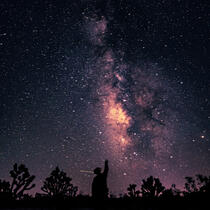 My friend silhouetted in front of the milky way galaxy.